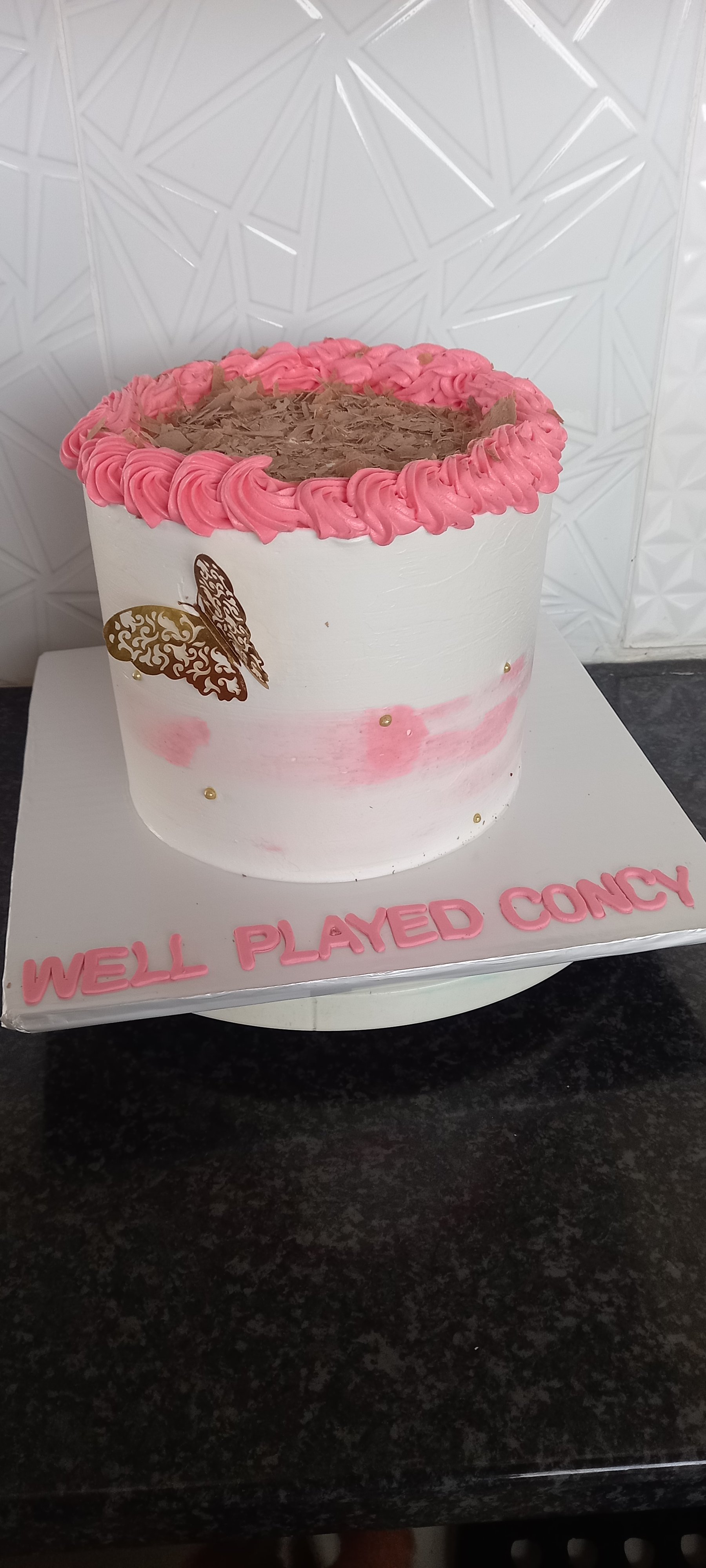 White and pink celebration cake with piped rosettes and Well Played Concy lettering
